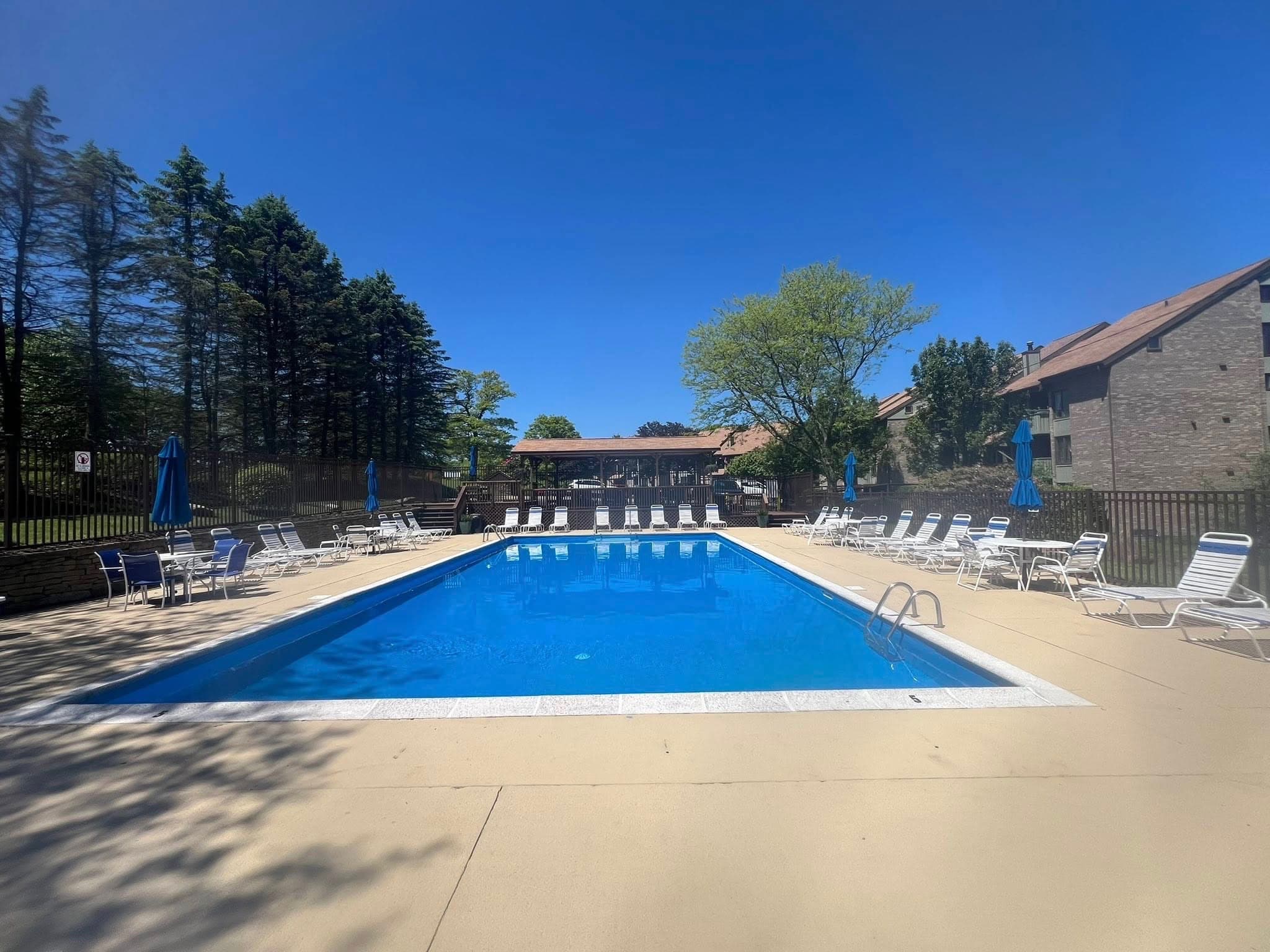 Seven Springs outdoor pool with lounge chairs and umbrellas on a sunny summer day