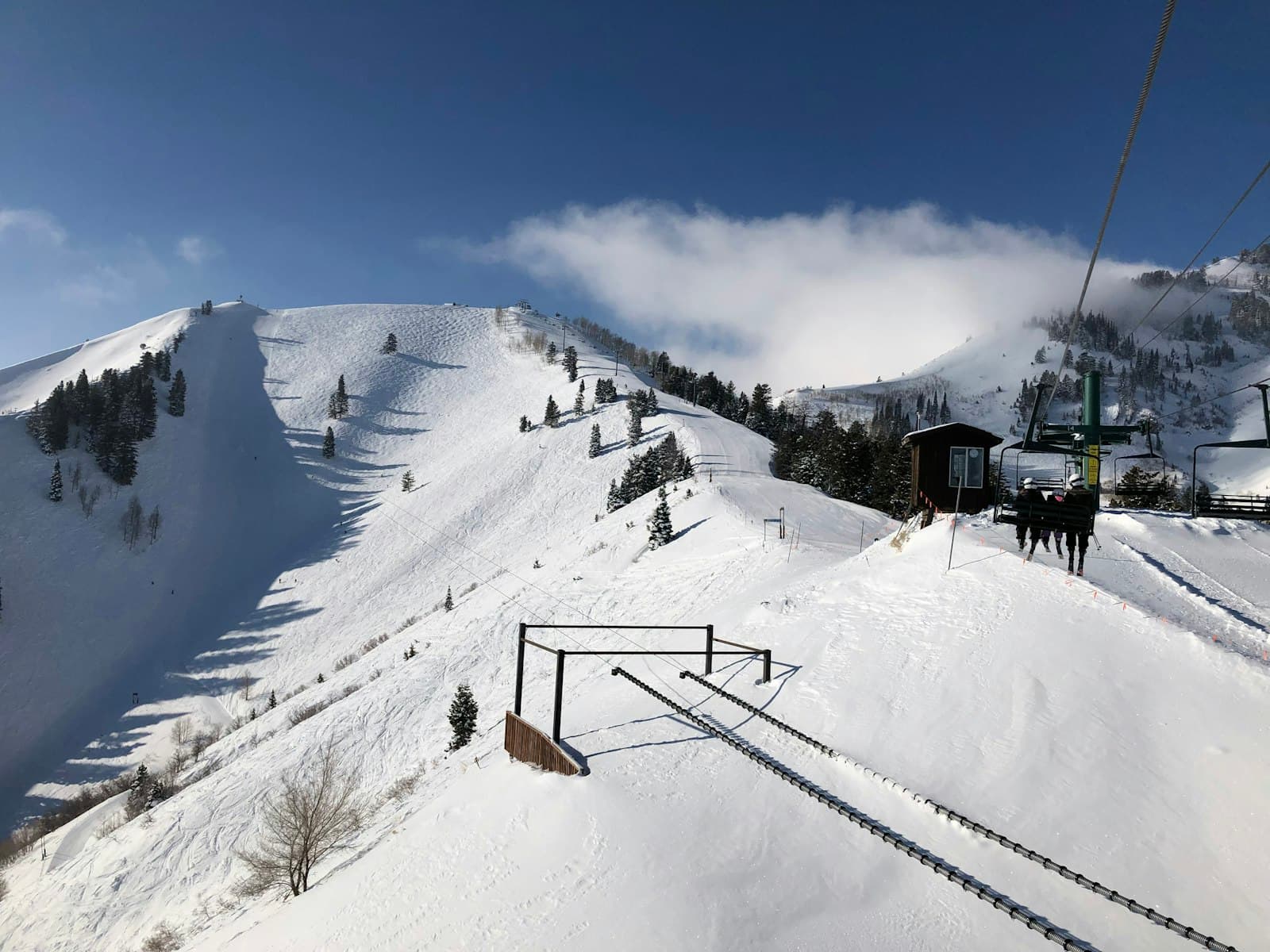 Snowy ski slope and chairlift on a blue-sky winter day at a Laurel Highlands resort