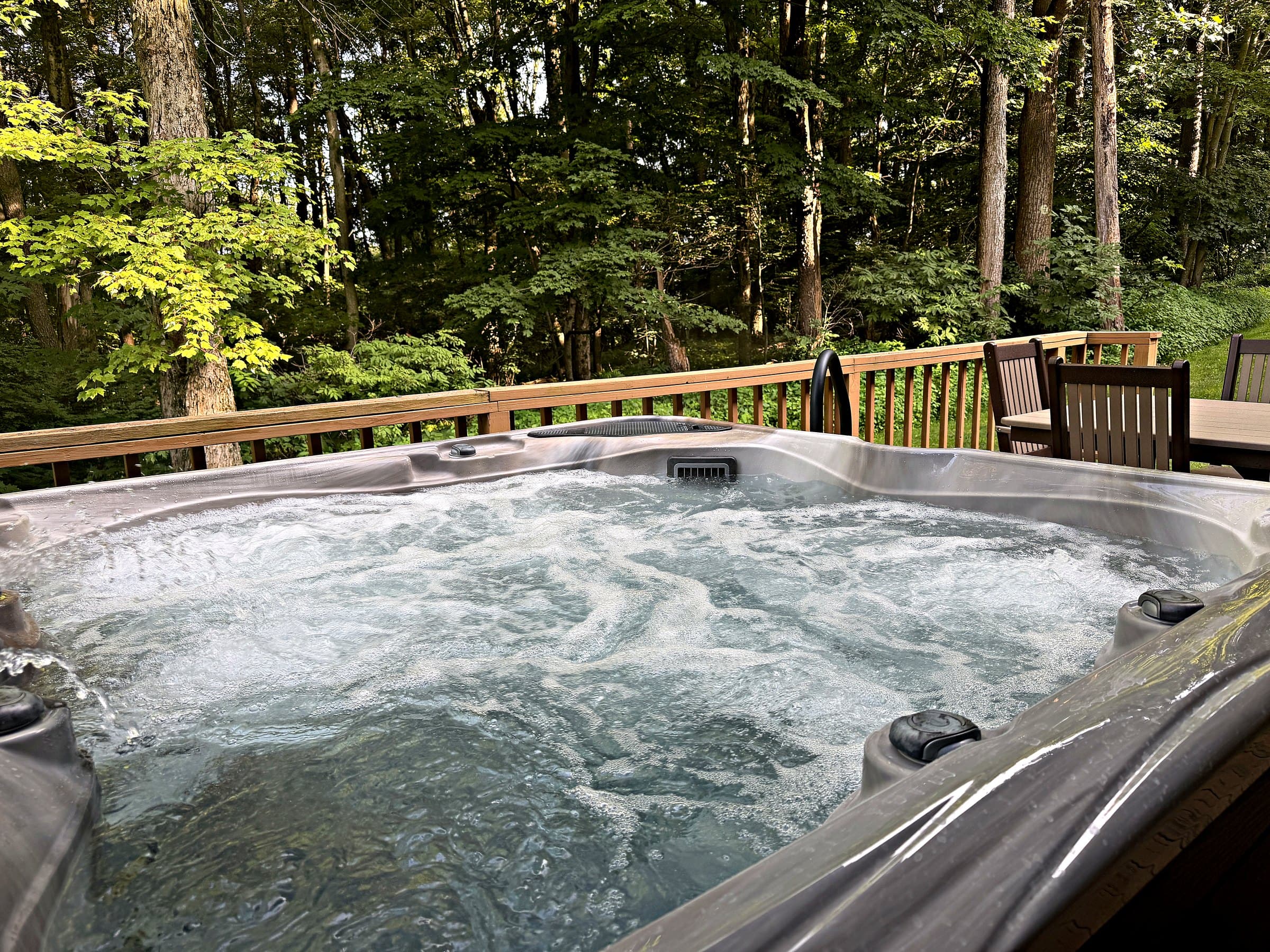 Private hot tub on the deck at Mountain Haven, framed by Laurel Highlands woods