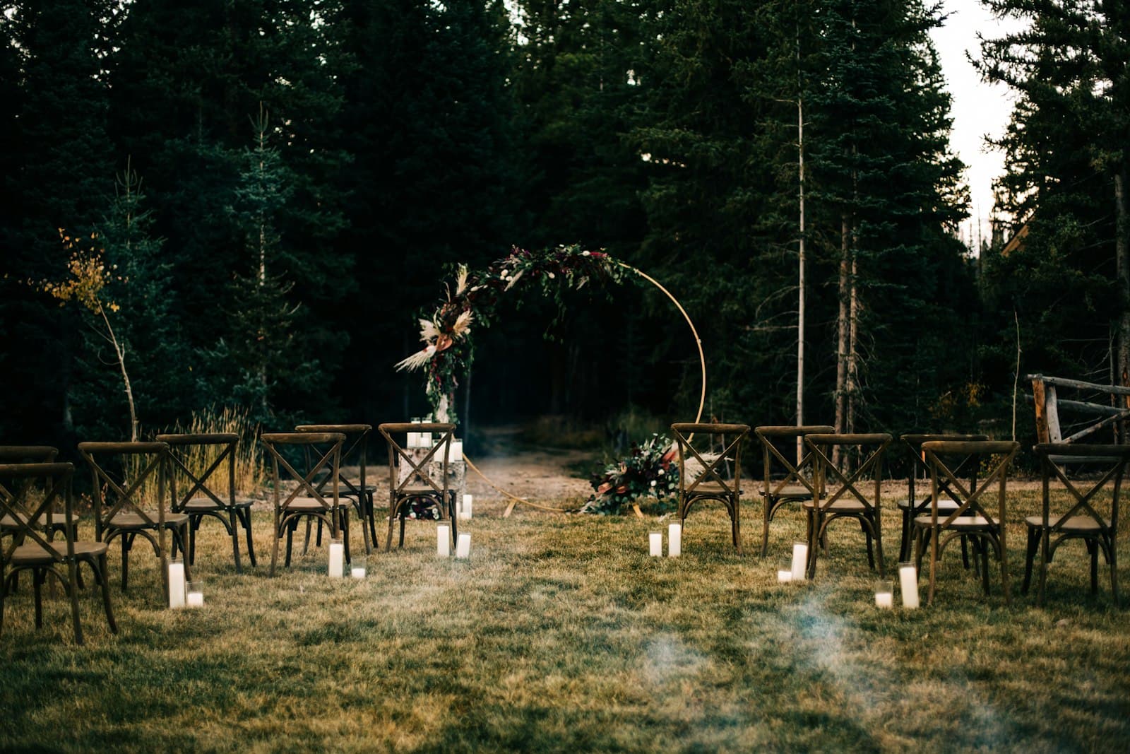 Elegant outdoor wedding ceremony set among the evergreens near Seven Springs